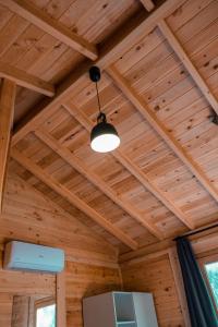 um tecto numa cabana de madeira com uma luz em İnlice Ünzile Bungalow İNLİCE KAMP em Fethiye