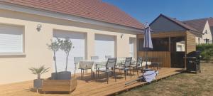 a wooden deck with a table and chairs on a house at Maison Les Ecloses in Chailloué