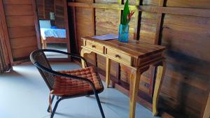 een stoel en een houten bureau met een vaas erop bij Morning Bali Bungalow in Canggu