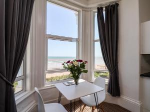 a table and chairs in a room with a window at 6 Beach View Beaconsfield House in Bridlington