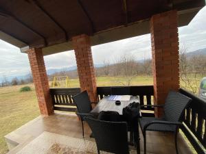a patio with a table and chairs on a porch at Šumska čarolija in Kosjeric