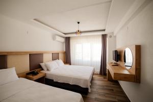 a hotel room with two beds and a television at Estia Hotel in Gokceada Town