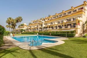 un complejo con piscina frente a un edificio en OleHolidays 1106 Romana Playa primera línea playa, en Marbella