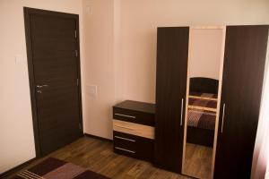 a bedroom with a black cabinet and a mirror at Apartment Kranevo in Kranevo