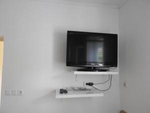 a flat screen tv sitting on a white wall at Apartman David in Barbat na Rabu