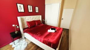 a red bedroom with a bed with a red comforter at Escapade Urbaine - Balnéothérapie - Cinéma au Cœur de la Ville in Mâcon