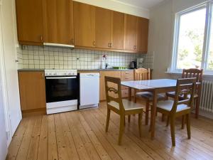 a kitchen with a table and a table and chairs at Stor etta på lugna söder in Växjö