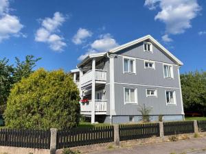 uma casa cinzenta com uma vedação à frente. em Stor etta på lugna söder em Växjö