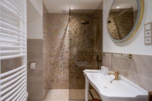 ein Bad mit einem Waschbecken, einem Spiegel und einer Dusche in der Unterkunft OrangeHomes Luxury apartment next to Gellért Hill in Budapest