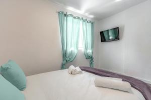 sypialnia z łóżkiem z telewizorem i ręcznikami w obiekcie Vistas al Teide y al mar 4 w Puerto de la Cruz