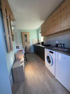 a kitchen with a washer and dryer in a room at Apartament U Waldka in Mechelinki
