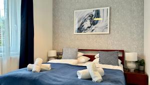 a bedroom with two beds with blue sheets and pillows at Hotel Dolce Vita in Balatonkenese