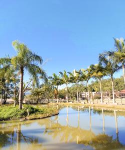 una piscina de agua con palmeras en una playa en Hotel Termas da Guarda, en Tubarão