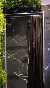 a glass door with a shower curtain in a room at Escapade Urbaine - Balnéothérapie - Cinéma au Cœur de la Ville in Mâcon +10 photos