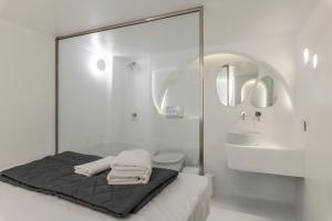 Baño blanco con cama y lavabo en MyCocoon Hostel, en Mykonos ciudad