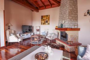 ein Wohnzimmer mit einem Kamin und einem Tisch in der Unterkunft Villa Mirador Los Hoyos in Las Palmas de Gran Canaria