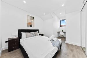 シドニーにあるmodern 3 bedroom townhous in Ashfieldのベッドルーム(大きな白いベッド1台、窓付)