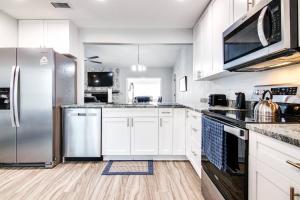 a kitchen with white cabinets and stainless steel appliances at Murray Dale Hideaway in Valrico