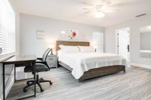 a white bedroom with a bed and a desk and a chair at Murray Dale Hideaway in Valrico