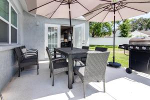 a patio with a wooden table and chairs with umbrellas at Murray Dale Hideaway in Valrico