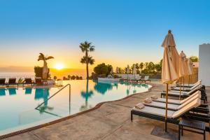 a pool with chairs and umbrellas at a resort at Las Terrazas de Abama Suites in Guía de Isora