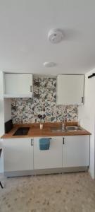 a kitchen with white cabinets and a sink at Apartamento Don Manuel in Rincón de la Victoria
