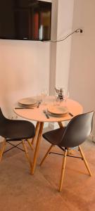 un tavolo e due sedie con piatti e bicchieri di Estudio Elizondo 2 a Benidorm