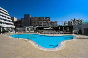 a large blue swimming pool in front of a building at Beach side -Luxury sea View Amazing pool Eilat in Eilat