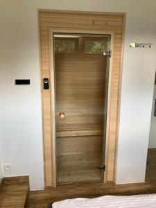 een houten deur in een kamer naast een bed bij Sara Apartament z sauną in Ustroń