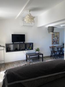 a living room with a couch and a tv on the wall at Villa 55 in Grimaud