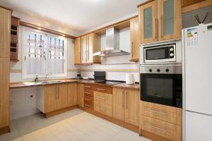 cocina con armarios de madera y nevera blanca en Casa vacacional Lomada en San Isidro