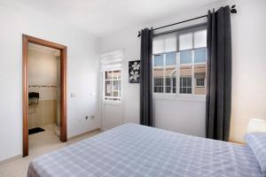 Un dormitorio con una cama azul y una ventana en Casa vacacional Lomada en San Isidro
