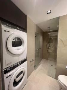 a bathroom with a washing machine and a shower at Uptown Parksuites BGC in Manila