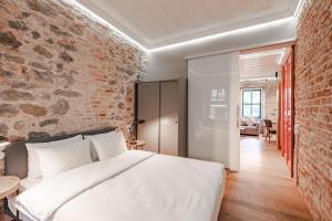 1 dormitorio con cama blanca y pared de ladrillo en Homie Suites - One Bedroom Apartment in Galata en Estambul
