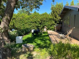 a yard with a tree and a wooden deck at Villa 55 in Grimaud