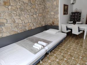 une chambre avec un lit et un mur en pierre dans l'établissement Stellar Suite, à Rab