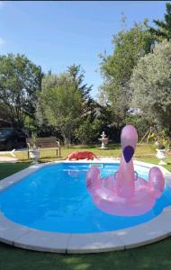 un cisne rosa flotante en una piscina en Hollidays home piscine et jardin en Plan-de-Cuques