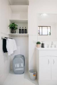 Un baño blanco con lavabo y espejo. en Stylish Family Bliss & SPA Heaven - The Gleam, en Dubbo