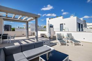 a patio with a couch and chairs on a roof at Bella Vista - House 4-6 people with swimming pool in San Miguel de Salinas in San Miguel de Salinas