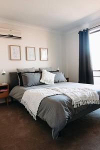 Un dormitorio con una cama grande con ventana. en Stylish Family Bliss & SPA Heaven - The Gleam, en Dubbo