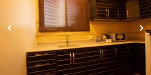 eine Küche mit einem Waschbecken und einem Fenster in der Unterkunft ريف الشرقية للشقق الفندقية in Dammam