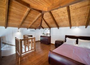a bedroom with a bed and wooden ceilings at Sunrise Vista by Vintage Travel in Vasiliki +27 photos