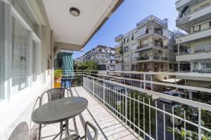 balkon ze stołem, krzesłami i budynkami w obiekcie Chic Flat w Balcony 3 min to Beach in Antalya w mieście Antalya