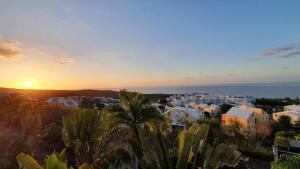 a sunset over a city with houses and palm trees at Le Panorama in Fleurimont