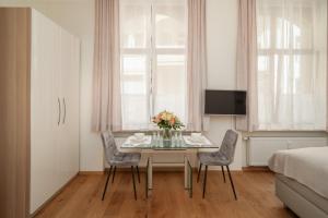 una sala da pranzo con tavolo, sedie e letto di Comfort Apart Baden-Baden a Baden-Baden
