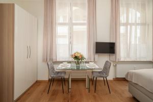 a dining room with a table and chairs and a bed at Comfort Apartment Baden-Baden in Baden-Baden