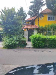 a yellow house with a driveway in front of it at Marytilla in Budapest