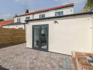 um edifício branco com portas deslizantes em 2 Staveley Cottages em Weaverthorpe