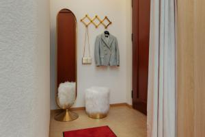 a dressing room with a suit and a mirror at Comfort Apartment Baden-Baden in Baden-Baden