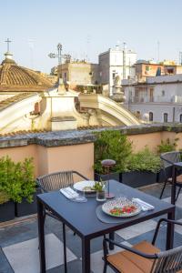 una mesa con platos de comida en el balcón en Sentho Roma, en Roma